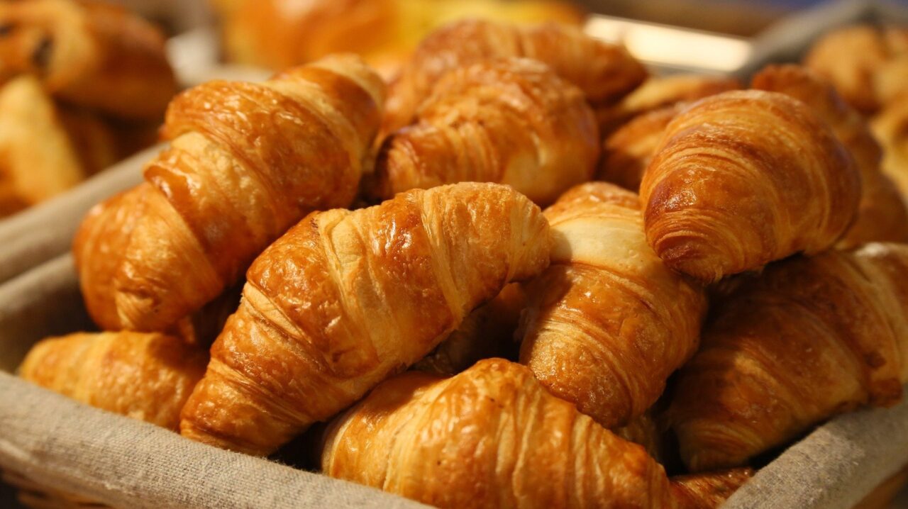 bottrop+klaeseners-auszeit+bild01.jpg: Frisch gebackene Croissants mit goldbrauner Kruste in einem Korb übereinandergestapelt.