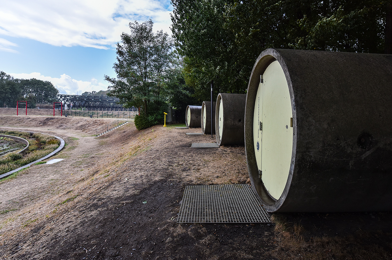 dasparkhotel BernePark, Bottrop: Mehrere große Betonröhren liegen nebeneinander auf einem grasbewachsenen Hügel.