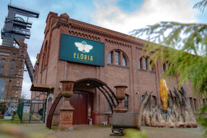ELORIA Erlebnisfabrik, Bottrop: Backsteingebäude der ELORIA Erlebnisfabrik in Bottrop mit großem Logo und historischem Förderturm.