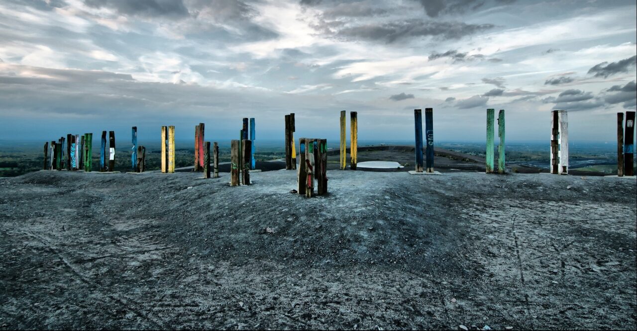 Halde Haniel, Bottrop: Bunte Holzstelen stehen auf der grauen Kuppe der Halde Haniel mit weitem Blick über das Ruhrgebiet.