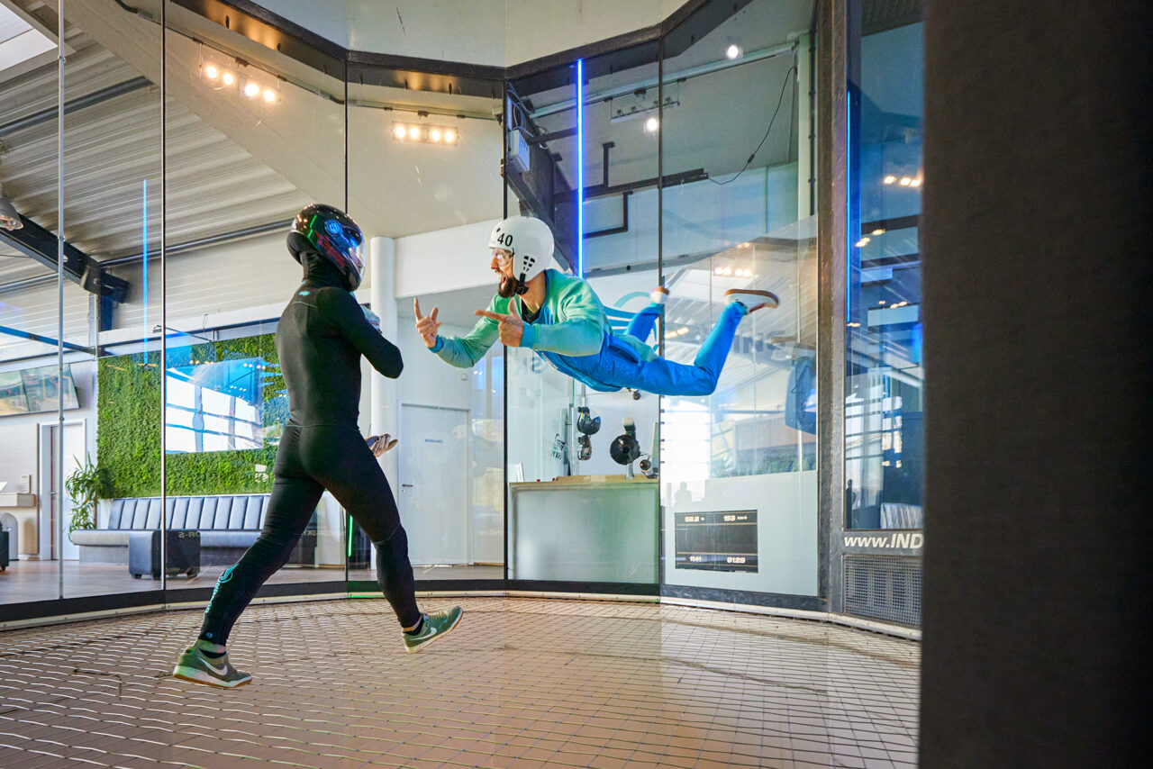 Indoor Skydiving Bottrop: Menschen im Windkanal beim Indoor-Skydiving in voller Montur.