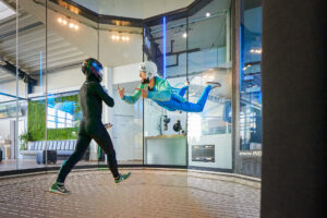 Indoor Skydiving Bottrop: Menschen im Windkanal beim Indoor-Skydiving in voller Montur.