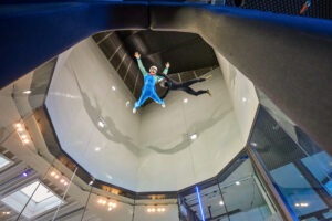 Indoor Skydiving Bottrop: ```html
Indoor-Skydiving in einer Windturbine: Eine Person schwebt frei im Windkanal, betreut von einem Guide.
```