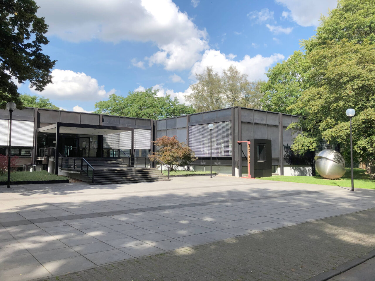 Josef Albers Museum Quadrat, Bottrop: Modernes Museumsgebäude mit klaren Linien, breiter Treppe und Skulptur im begrünten Außenbereich.