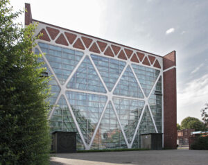 KulturkircheHeiligKreuz.jpg: Backsteinbau mit großer Glasfassade und markanten weißen Streben der Kulturkirche Heilig Kreuz Bottrop