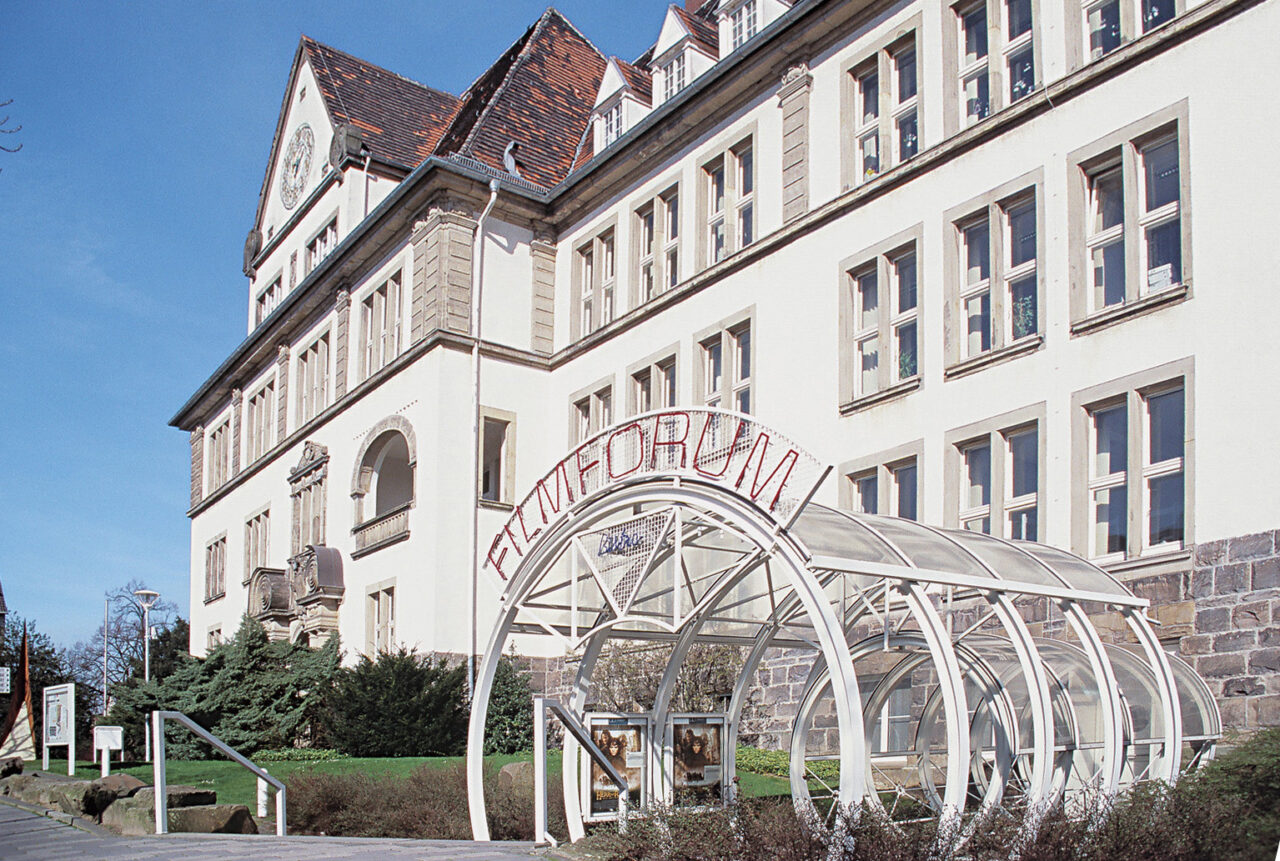 KulturzentrumAugustEverding.jpg: Historisches Gebäude mit Glasbogen-Eingang und dem Schriftzug Filmforum in Bottrop.