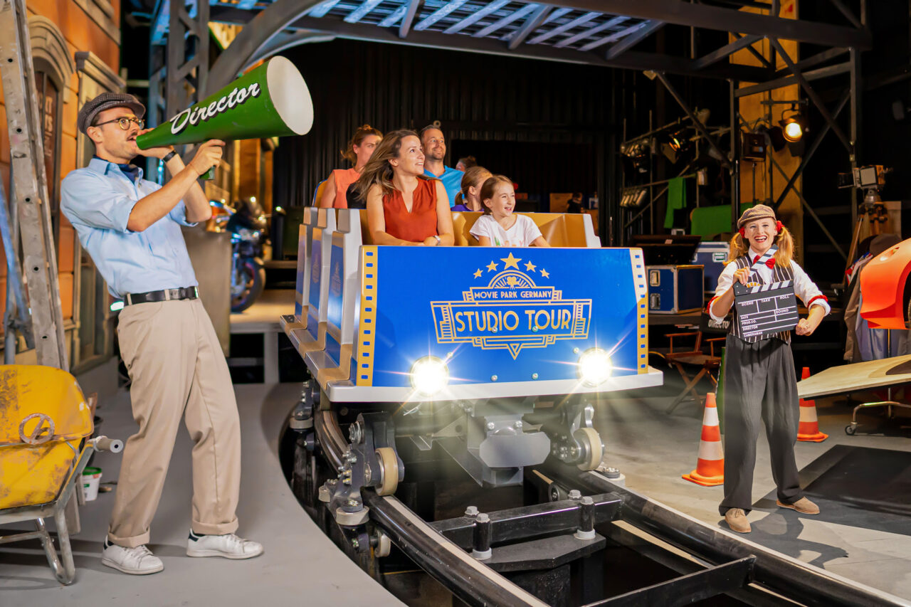 Movie Park Germany, Bottrop, Studio Tour: Menschen in einem Studiowagen erleben eine Filmszene mit Requisiten im Movie Park Germany.