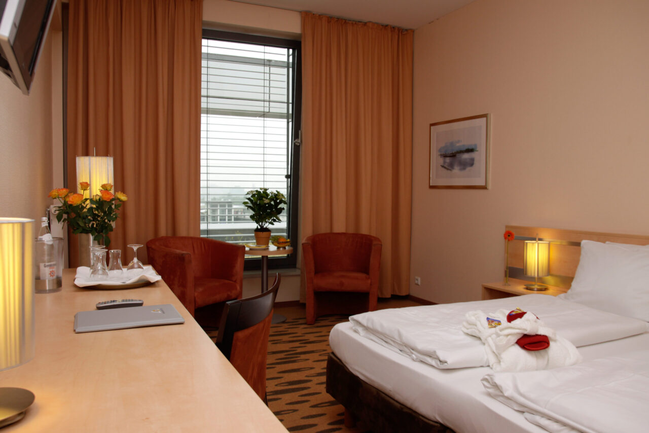 Rhein-Ruhr-Hotel, Bottrop: Modern eingerichtetes Hotelzimmer mit Doppelbett, Schreibtisch, Sitzbereich und großem Fenster.