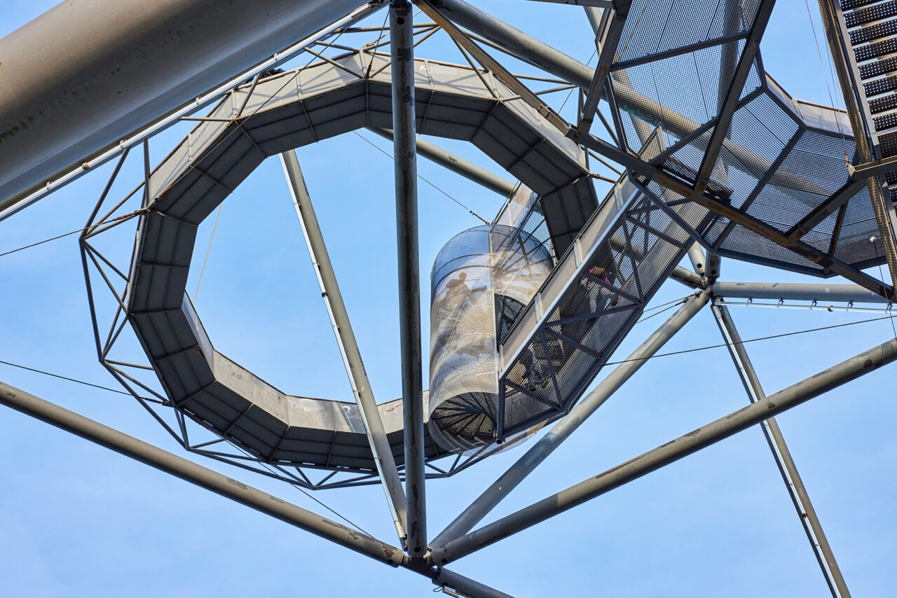 Tetraeder Halde Beckstr. Bottrop: Stählerne Struktur des Tetraeders Bottrop mit kreisförmigem Element vor blauem Himmel.