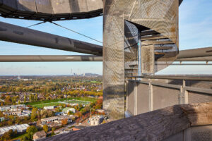 Tetraeder Halde Beckstr. Bottrop: Spiraltreppe aus Stahl des Tetraeders Bottrop mit weitem Blick über Stadt und Industrieanlagen.