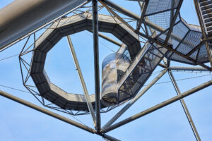 Tetraeder Halde Beckstr. Bottrop: Stählerne Struktur des Tetraeders Bottrop mit kreisförmigem Element vor blauem Himmel.